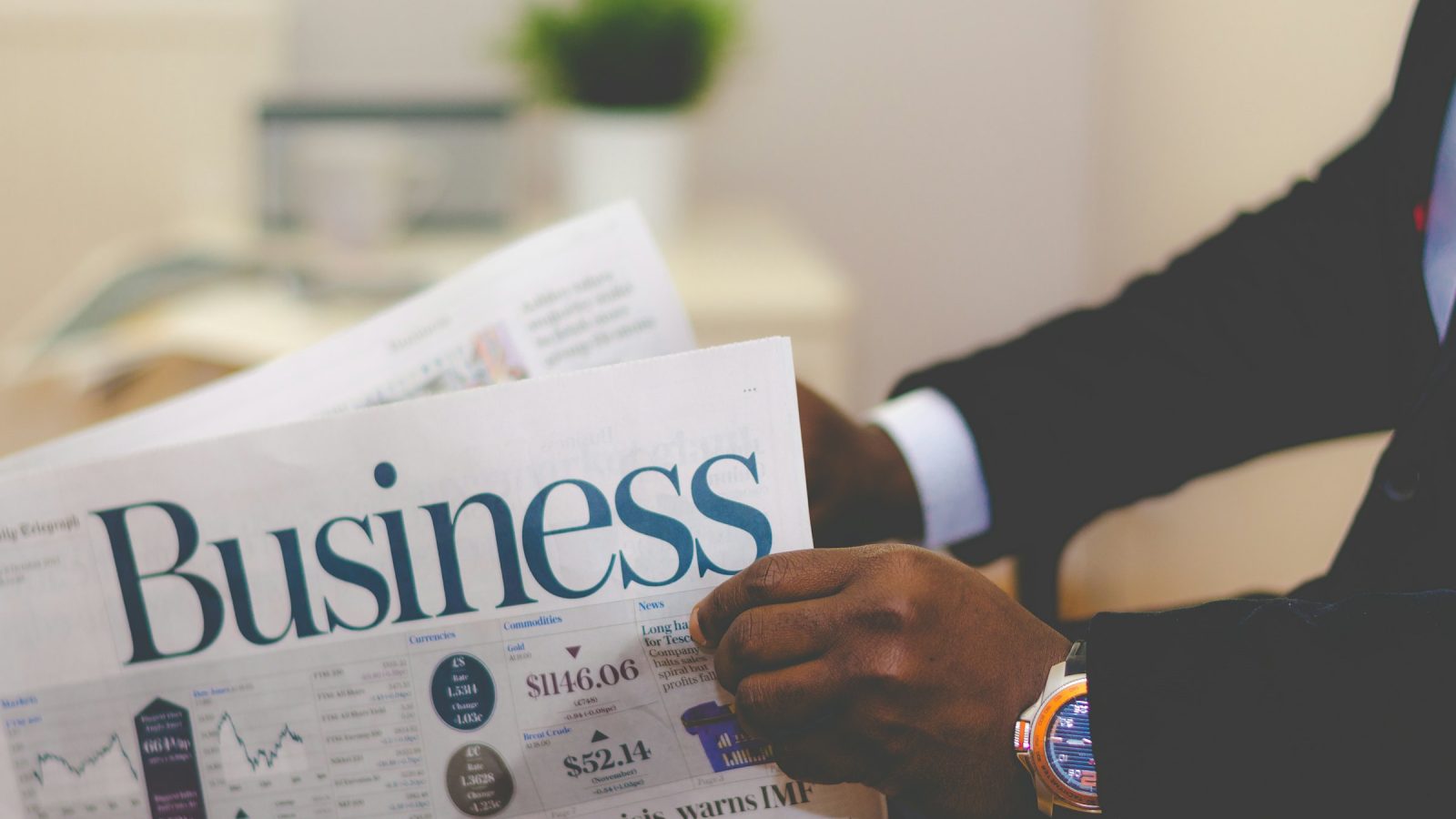 Business newspaper held by an investor